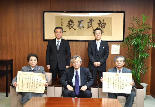 遠藤学長（中央）へ受章の報告をする嘉戸氏（前列右）、吉田氏（前列左）