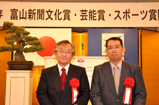 受賞を喜ぶ塚田教授（右）と遠藤学長（左）
